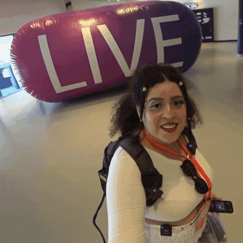a woman stands in front of an inflatable balloon that says " live "