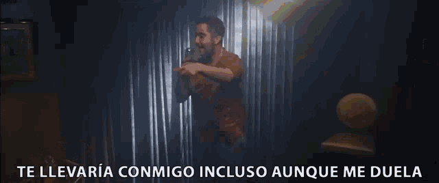 a man singing into a microphone with the words " te llevaria conmigo incluso aunque me duela " below him