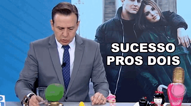 a man in a suit and tie says sucesso pros dois in front of a picture of a couple