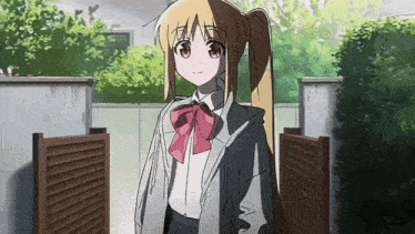 a girl in a school uniform is standing in front of a building