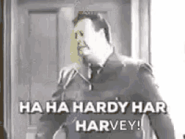 a man in a suit and tie is laughing while talking on a phone .