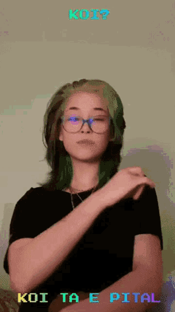 a girl with green hair and glasses says koi ta e pital in sign language