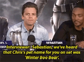 a man sits at a table with a microphone and says sebastian