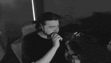 a man with a beard is sitting in a chair in front of a microphone .
