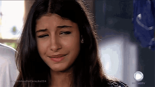 a girl is crying in front of a tv screen that says recordtv