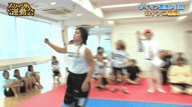 a group of people are dancing in a room with chinese writing on the walls