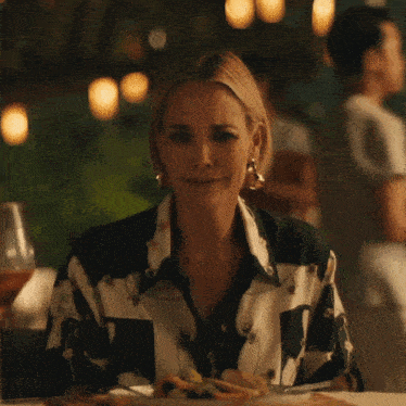 a woman is sitting at a table with a plate of food in front of her