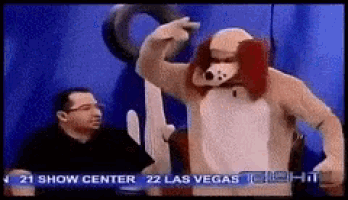 a man in a dog costume is standing in front of a sign that says 21 show center 22 las vegas