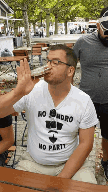 a man wearing a shirt that says no sondro no party is drinking a beer