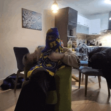 a person is sitting in a chair wearing a scarf around their head .