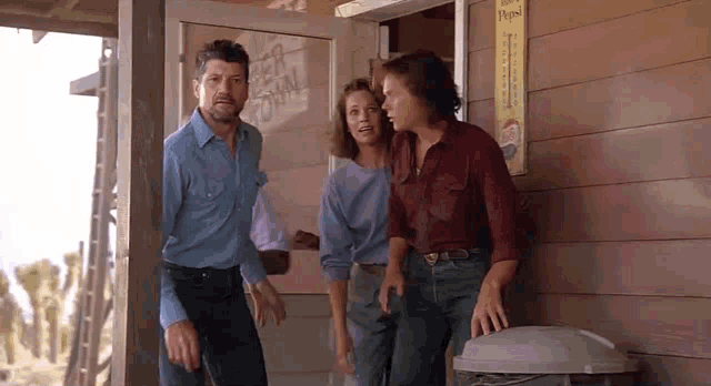 a group of people are standing outside of a building with a pepsi sign on the side .