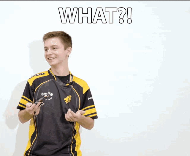 a young man wearing a black and yellow shirt with the word what on it