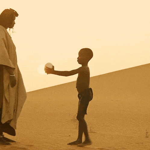 a man in a poncho stands next to a boy in a desert