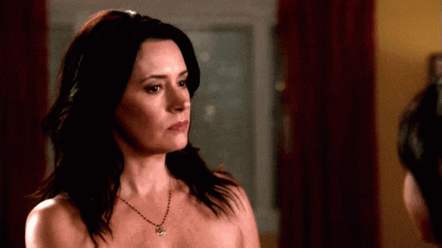 a woman without a shirt is wearing a necklace with a pendant