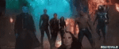 a group of people are standing in a dark room .