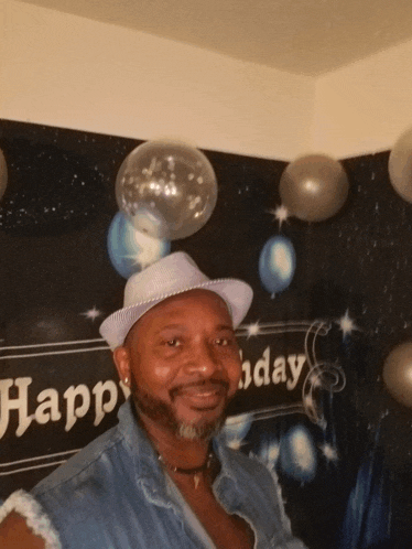 a man stands in front of a sign that says happy birthday