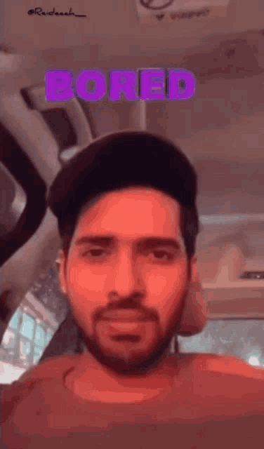 a man with a beard is wearing a hat and the word bored is above him