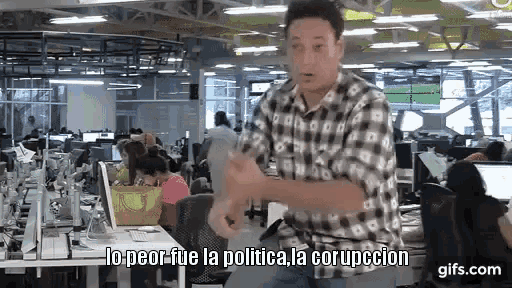 a man in a plaid shirt is dancing in an office with the words " lo peor fue la politica la corruption " written below him