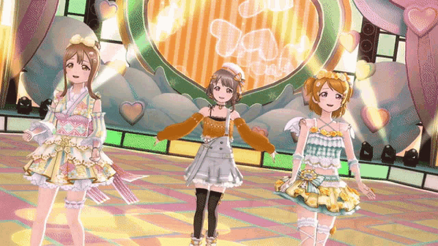 three anime girls are standing in front of a stage with a heart in the background