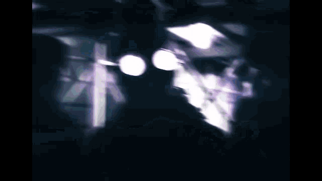 a man wearing glasses and a gas mask is standing in a dark room