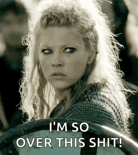 a woman with blonde hair is holding a shield and says i 'm so over this shit !