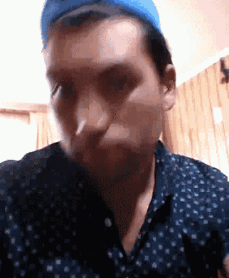 a man wearing a blue hat and a blue shirt looks at the camera