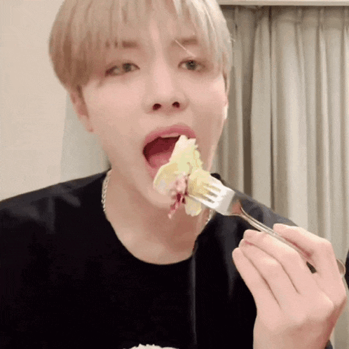 a man is eating a piece of food with a fork in his mouth