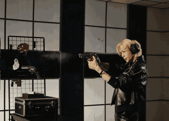 a man wearing headphones is holding a gun in a room