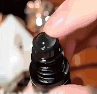 a close up of a person 's hand holding a bottle