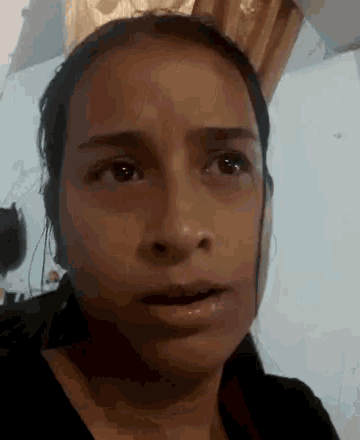 a close up of a woman 's face making a funny face