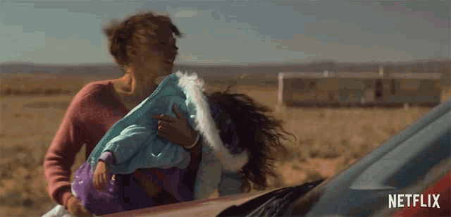a woman holding a child in front of a netflix ad