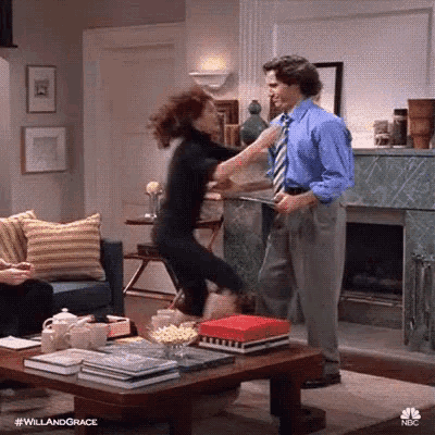 a man and a woman are dancing in a living room with a coffee table .