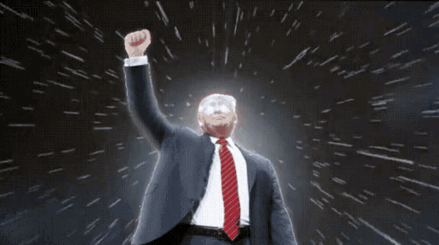 a man in a suit and tie holds his fist up in the air
