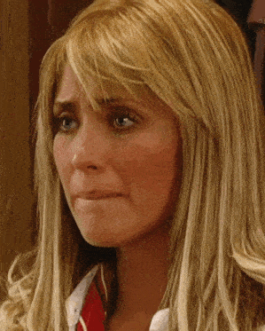 a woman with blonde hair and blue eyes is crying