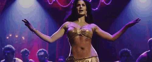 a woman is dancing on a stage with her arms outstretched in front of a crowd of people .