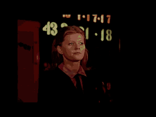 a woman stands in front of a sign that says ' 11:17 ' on it