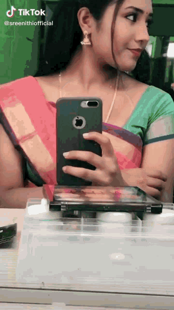 a woman is taking a picture of herself in a mirror with a tik tok watermark