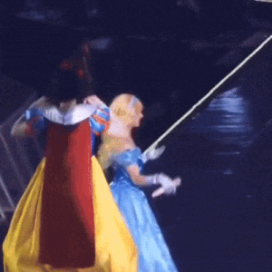 a doll dressed as snow white and cinderella walking on a stage
