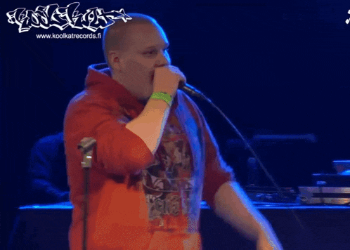 a man singing into a microphone with the website www.koolkatrecords.fi visible in the background