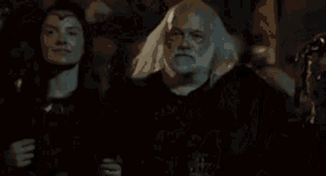 a group of people are standing around a man with a beard and a woman .