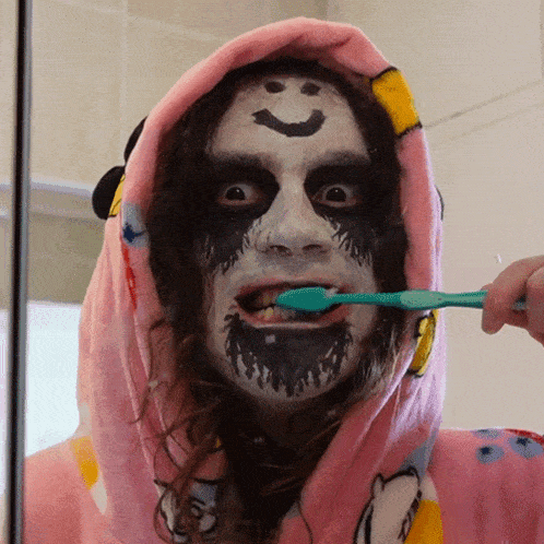 a person with a smiley face on their face brushing their teeth