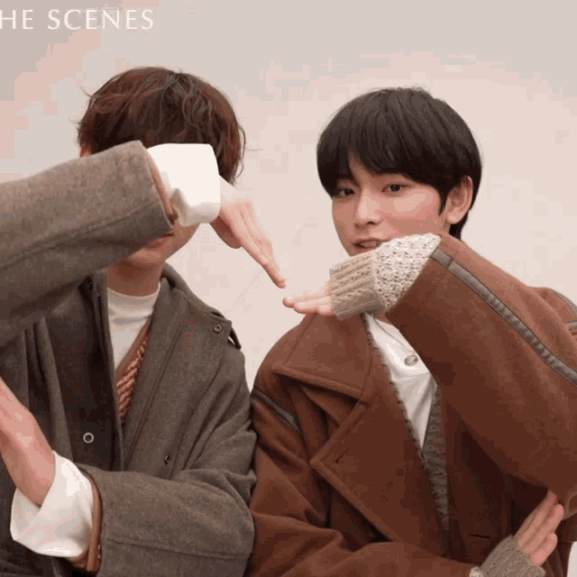 a couple of people standing next to each other with the words " the scenes " in the background