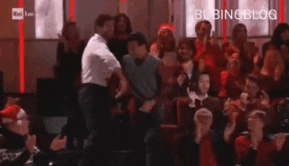 a man is dancing in front of a crowd of people who are clapping .