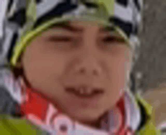 a close up of a person wearing a helmet , scarf and goggles .