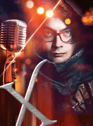 a man wearing glasses stands in front of a microphone with the letter x in the foreground