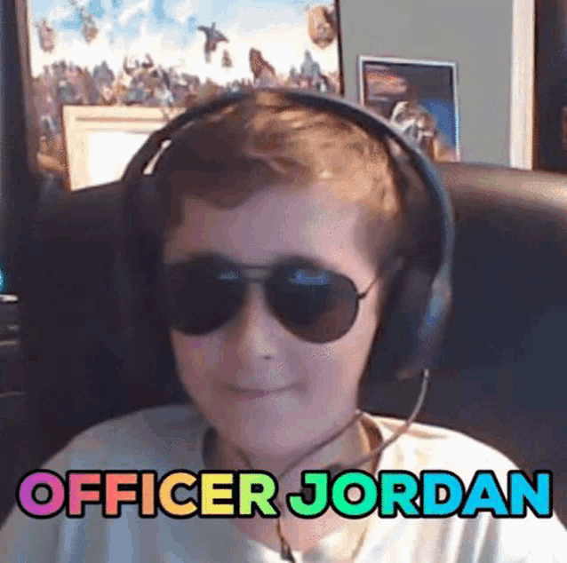 a young boy wearing headphones and sunglasses is sitting in a chair and says officer jordan .