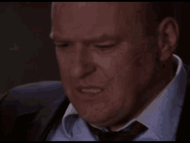a man in a suit and tie is making a face