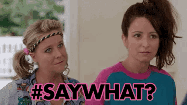 two women are standing next to each other in a room and one of them is asking the other to say what .