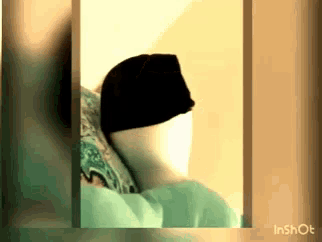 a person wearing a black hat is laying in bed .