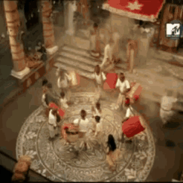 a group of people are dancing in a room with a circular pattern